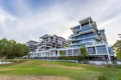 an apartment building with a lawn in front of it at Elegant Studio Without Balcony- Damac Hills, Dubai - Host & Stay in Dubai