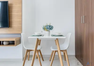 a table with white chairs and a vase of flowers on it at Elegant Studio Without Balcony- Damac Hills, Dubai - Host & Stay in Dubai