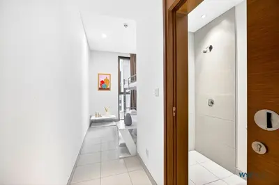 a hallway with white walls and white tile floors at Lush 2BR & Maids City Walk with Burj Khalifa View in Dubai