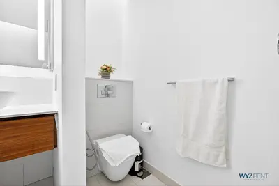 a white bathroom with a toilet and a sink at Lush 2BR & Maids City Walk with Burj Khalifa View in Dubai