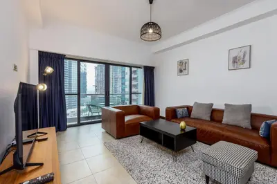 a living room with a couch and a tv at Full Lake View - 1BR Apartment in Goldcrest Views,Cluster V,JLT - Allsopp & Allsopp in Dubai