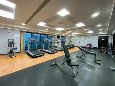a gym with several treadmills and elliptical machines at Full Lake View - 1BR Apartment in Goldcrest Views,Cluster V,JLT - Allsopp & Allsopp in Dubai
