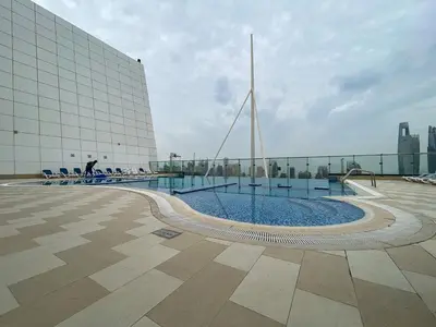 a building with a swimming pool in front of a building at Full Lake View - 1BR Apartment in Goldcrest Views,Cluster V,JLT - Allsopp & Allsopp in Dubai