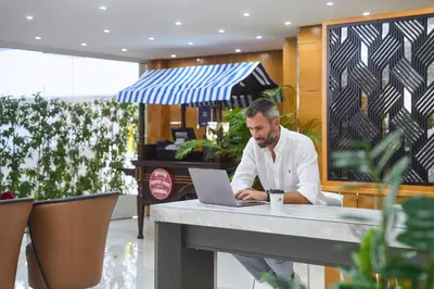 a man sitting at a table using a laptop computer at Golden Sands Bur Dubai in Dubai