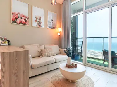a living room with a couch and a table at HiGuest - New! Stunning sea view studio, Balcony, Pool in Dubai