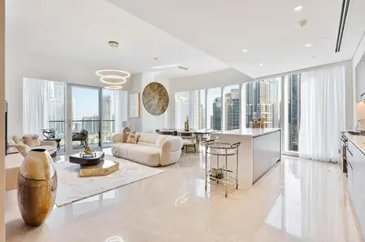 a living room with white furniture and large windows at Luxury 3BR Apartment with Burj Khalifa Views in Dubai
