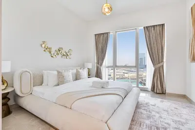 a white couch in a room with a large window at Luxury 3BR Apartment with Burj Khalifa Views in Dubai
