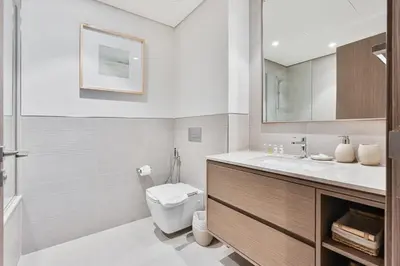 a white bathroom with a toilet and a sink at Luxury 3BR Apartment with Burj Khalifa Views in Dubai
