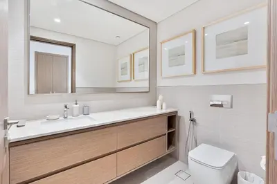 a bathroom with a sink and a toilet and a mirror at Luxury 3BR Apartment with Burj Khalifa Views in Dubai