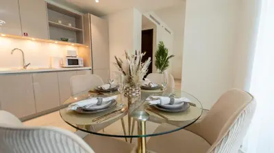 a dining room with a glass table and chairs at Modern 1BR in Creek Vistas Grande, Burj Khalifa View in Dubai