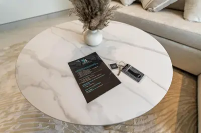 a white table with a vase on top of it at Modern 1BR in Creek Vistas Grande, Burj Khalifa View in Dubai