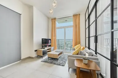 a living room with a couch and a tv at Bright & Trendy 2BR in Collective, Dubai Hills in Dubai