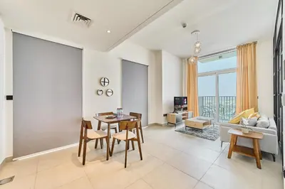 a living room with a table and chairs and a couch at Bright & Trendy 2BR in Collective, Dubai Hills in Dubai