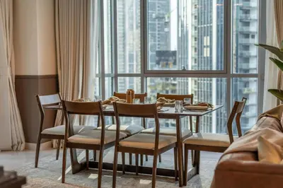 a dining room with a table and chairs and a large window at 2-Bedroom Apartment with Full Burj Khalifa & Opera House Views Just 9 Min Walk to Dubai Mall! in Dubai
