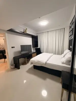 a bedroom with a bed and a desk and a computer at 1 BR in Mall St in Dubai