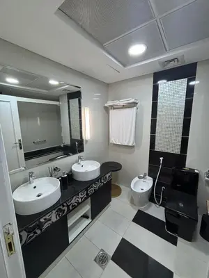 a bathroom with two sinks and a toilet at 1 BR in Mall St in Dubai