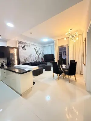a kitchen and living room with a couch and a table at 1 BR in Mall St in Dubai