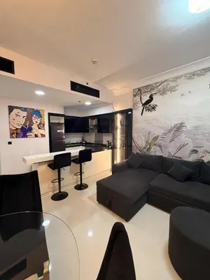 a living room with a couch and a kitchen at 1 BR in Mall St in Dubai