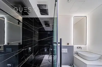 a bathroom with a glass shower and a sink at Terraces Marasi Drive, Business Bay in Dubai