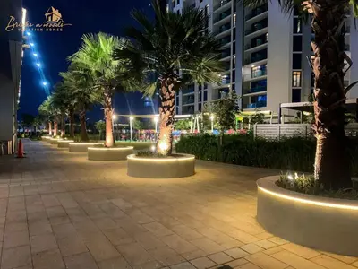 a row of palm trees on a sidewalk at night at Classic Canal View 2 Bhk 6pax in Dubai