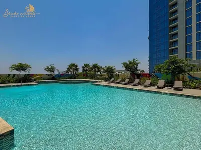 a large swimming pool with chairs and a building at Classic Canal View 2 Bhk 6pax in Dubai