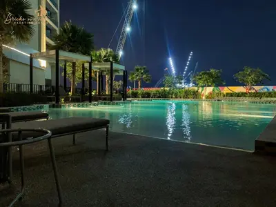 a large swimming pool at night with lights at Classic Canal View 2 Bhk 6pax in Dubai