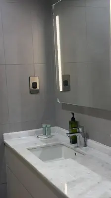 a bathroom with a white sink and a mirror at Royal bay Azizi Palm Jumeirah in Dubai