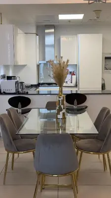 a dining room with a glass table and chairs at Royal bay Azizi Palm Jumeirah in Dubai