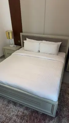 a bed with white sheets and pillows in a room at Royal bay Azizi Palm Jumeirah in Dubai
