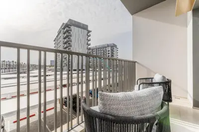a balcony with a chair and a view of a city at Community Views Studio Near Nad Al Sheba Gardens with Balcony, MAG 980, Mohammad Bin Rashid by Deluxe Holiday Homes in Dubai