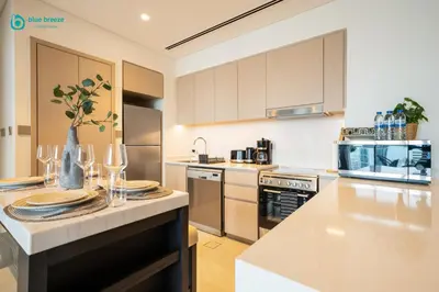 a kitchen with a table with plates and wine glasses at Blue Breeze - Luxury Apartment in Downtown in Dubai