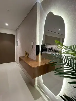 a living room with a wooden bench and a kitchen at Blue Breeze - Luxury Apartment in Downtown in Dubai