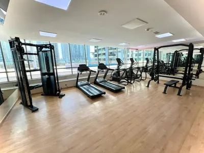 a gym with a bunch of treadmills in a room at BRAND NEW luxury & modern in JLT in Dubai
