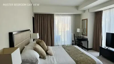 a bedroom with a bed and a desk and a television at JW Marriot Hotel Residence - Two bedroom Suite in Dubai