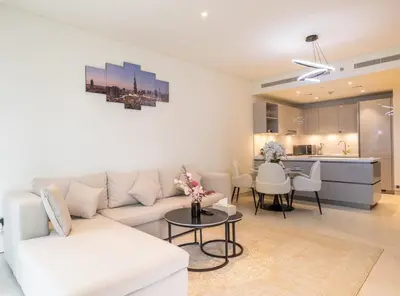 a living room with a white couch and a table at Premium Chic Fully Furnished 1 BR in Sobha Hartland in Dubai