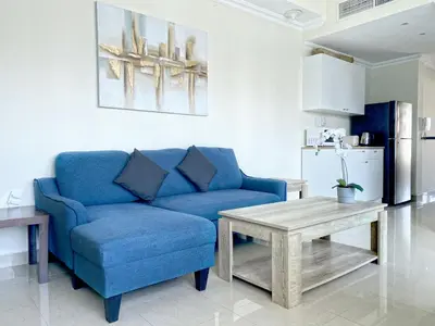 a living room with a blue couch and a table at Dubai Marina View, close to beach & metro in Dubai