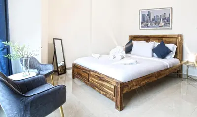 a bedroom with a wooden bed with a chair and a chair at Dubai Marina View, close to beach & metro in Dubai