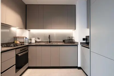 a kitchen with white cabinets and a sink at Luxury 2BR Burj Khalifa and Canal View Pool Jacuzzi in Dubai