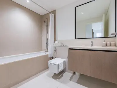 a bathroom with a tub and a toilet and a sink at the 'Paris' Condo - Stylish 2Bd with Burj View in Dubai