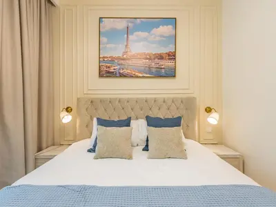 a bedroom with a bed and a picture of the eiffel tower at the 'Paris' Condo - Stylish 2Bd with Burj View in Dubai