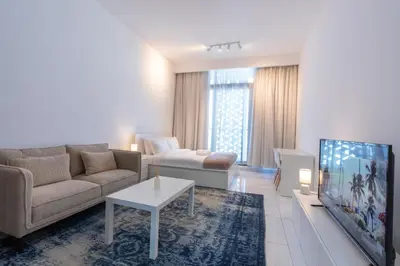 a living room with a couch and a tv at Vibrant Studio with Gym Access in Dubai