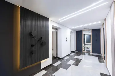 a hallway with a black wall and a tile floor at Vibrant Studio with Gym Access in Dubai