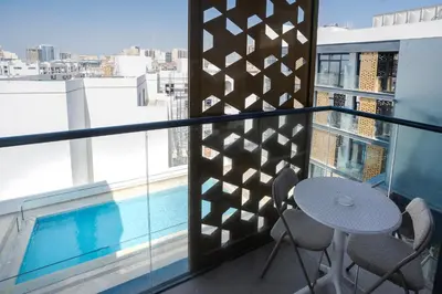 a balcony with a table and chairs and a pool at Vibrant Studio with Gym Access in Dubai
