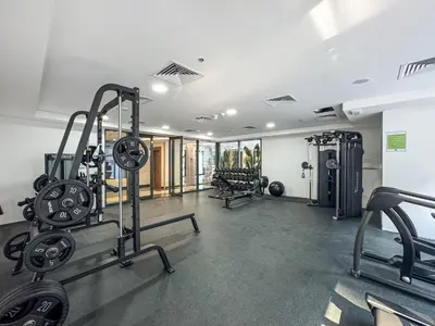 a gym with treadmills and machines in a room at Vibrant Studio with Gym Access in Dubai