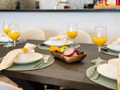 a table with plates of food and glasses of orange juice at Burj View 3BDR with Rooftop Infinity Pool in Dubai
