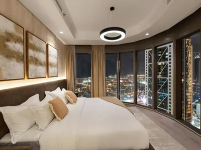 a bedroom with a large white bed with a city view at Burj View 3BDR with Rooftop Infinity Pool in Dubai
