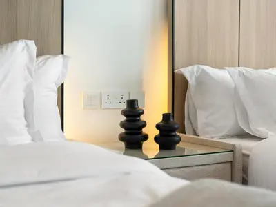 a bed with two black chess pieces on a glass table at Burj View 3BDR with Rooftop Infinity Pool in Dubai