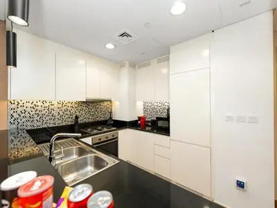 a kitchen with white cabinets and a sink at Burj View 3BDR with Rooftop Infinity Pool in Dubai