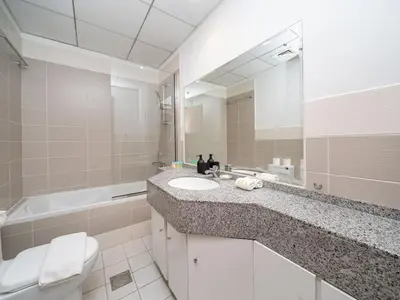 a bathroom with a sink and a toilet and a mirror at Elegant and Spacious 2-Bedroom Apartment in JVT in Dubai