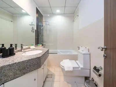 a bathroom with a toilet and a sink and a tub at Elegant and Spacious 2-Bedroom Apartment in JVT in Dubai